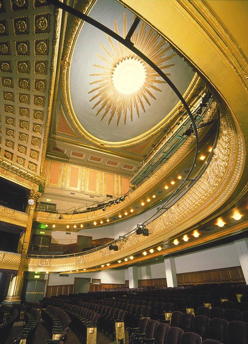 Interior view of lavish Geary Theater in San Francisco, CA with sweeping forms and upholstered seating