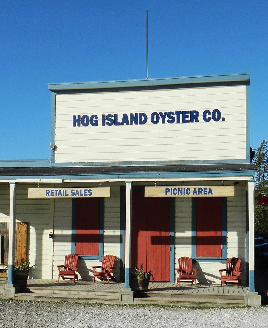 Exterior view of historical wood building with 'Hog Island Oyster Co.' signage above charming wood porch