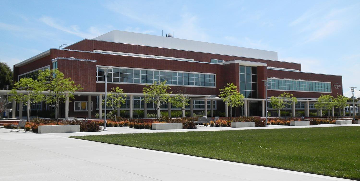 Exterior view of Richmond Civic Center in Richmond, CA showing brick and glass facade with landscaping in the foreground